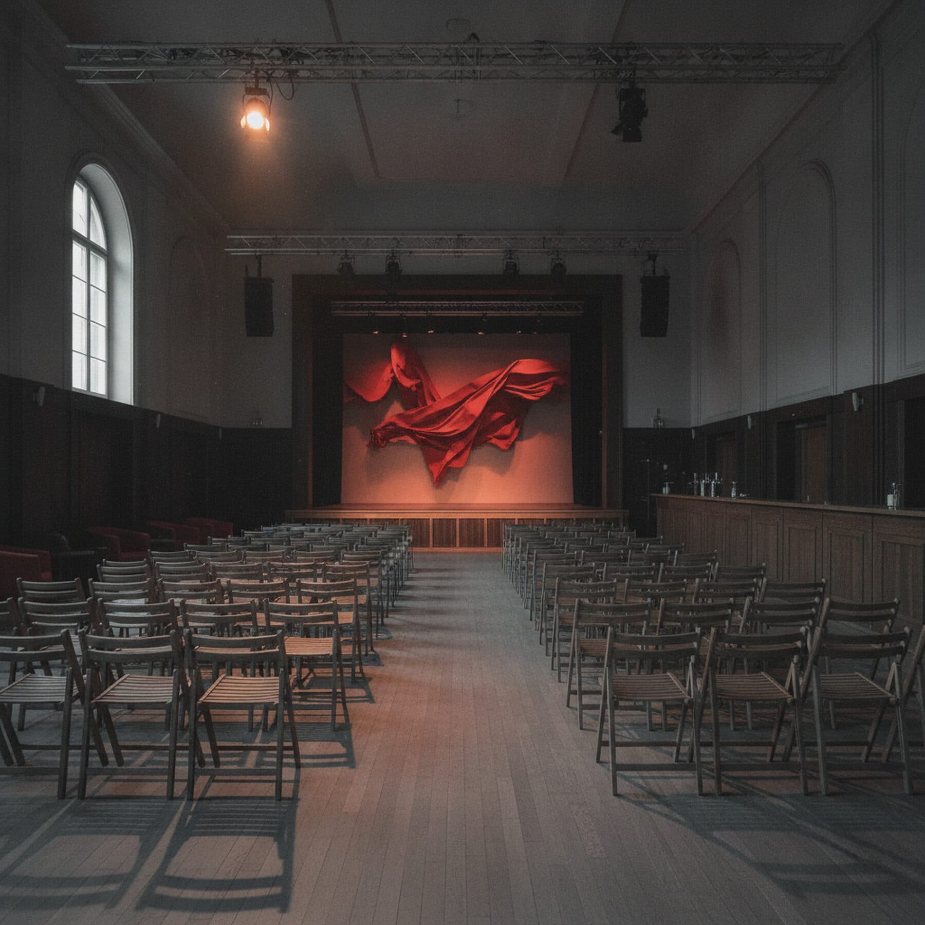 Leerer bestuhlter Saal vor dem Einlass, Bühne im warmen Licht